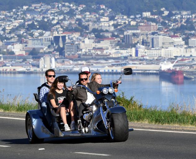 Andrew Sim drives his new 350 Chev-powered trike up Highcliff Rd with (from left) Rachel Horrell ...