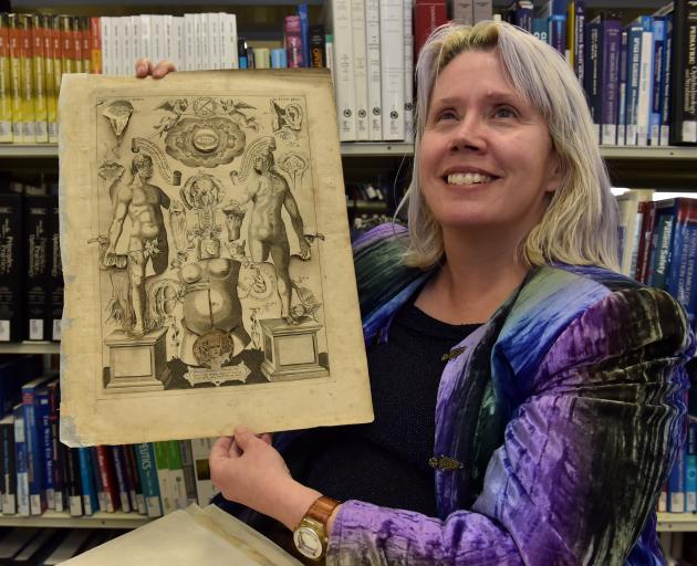 University of Otago medical academic Dr Katherine Hall holds a mid-17th century medical text....
