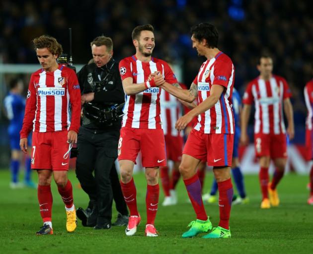 Antoine Griezmann of Atletico Madrid walks alongside Saul Niguez and Stefan Savic after clinching...