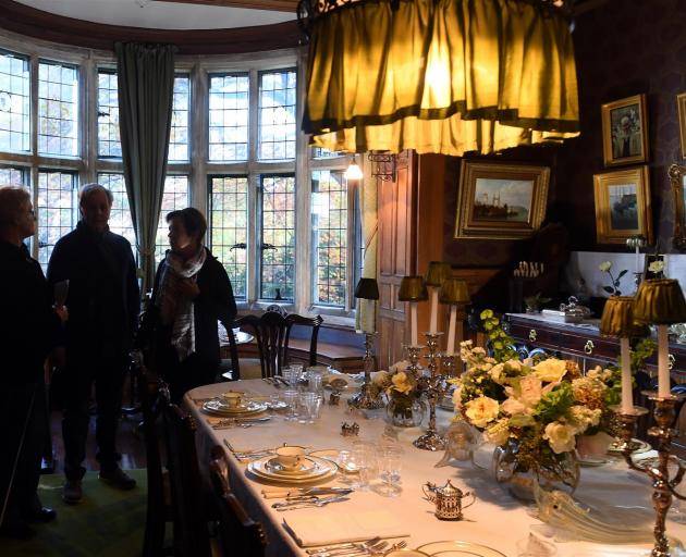 Olveston Historic Home interim manager Bronwyn Simes (left) with tourists Steve and Louise Mitchell, of Melbourne, in the dining room on a free tour of the Dunedin home yesterday. Photo: Stephen Jaquiery.