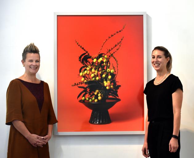 Milford Gallery curators Lisa Wilkie (left) and Vanessa Jones with Ann Shelton’s The Courtesan, Poroporo (Solanum sp.). Photo: Peter McIntosh.