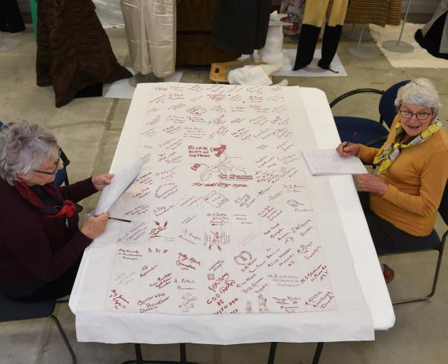 Jan Wilson (left) and Ingrid Emerson examine one of the signature quilts that will appear in the...