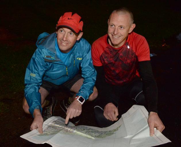 Supporter Bruce Adams (left) and long-distance runner Glenn Sutton study a map of Haast in Dunedin last night. Photo: Linda Robertson.