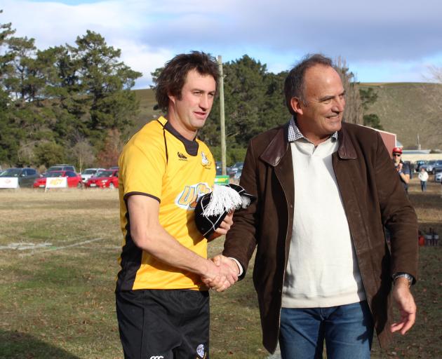 Ben Purvis (left) is presented with an All Black cap to replace his  late father Neil’s cap by...