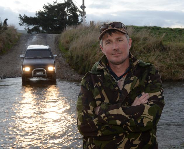 Callum Fissenden cleans his 4WD in a ford in East Taieri. Photo: Linda Robertson