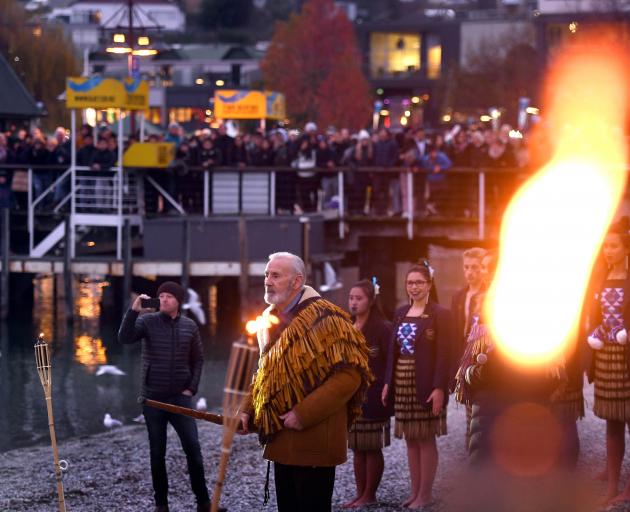 The setting sun tinted the sky red, birds circled and waka are paddled ashore to a formal...