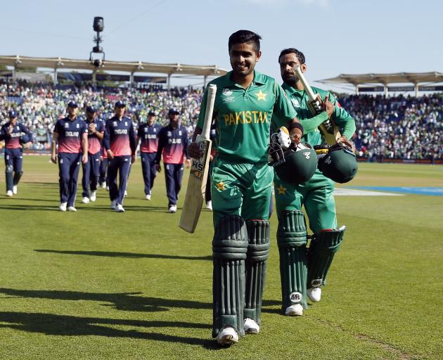 Pakistan batsmen Mohammad Hafeez and Babar Azam celebrate as they walk off after winning the...