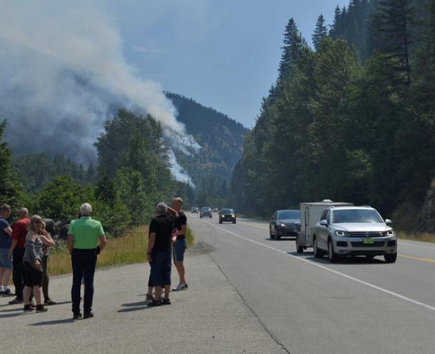 Tourists from Denmark stop to photograph one of several wildfires burning near Little Fort, Canada. Photo: Reuters