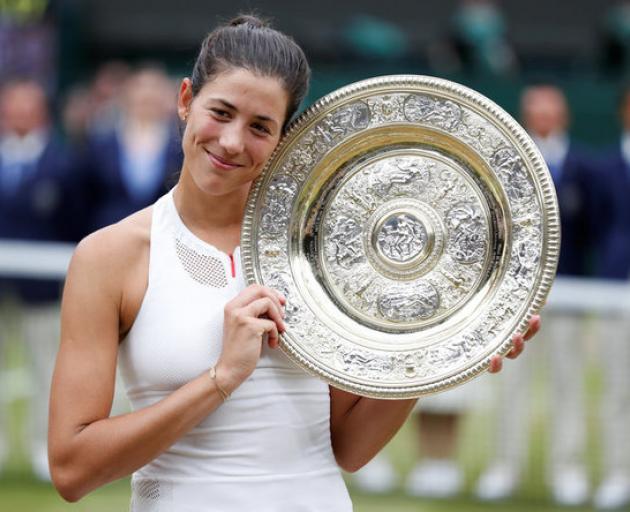 Spain’s Garbine Muguruza poses with the trophy as she celebrates winning the final against Venus Williams