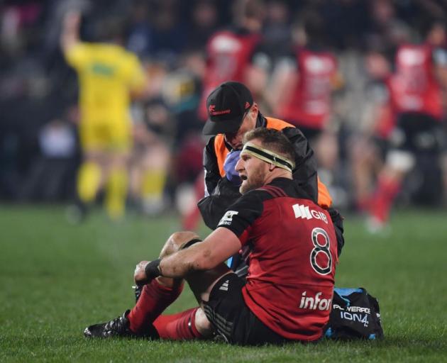 Kieran Read gets his knee looked at after picking up an injury during yesterday's game between...