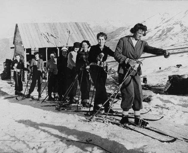 Skiers hold on to the rope tow designed and constructed by jet-boat inventor Bill Hamilton during Coronet Peak's opening day in July 1947. Tomorrow night the NZSki-owned ski area will celebrate its 70th birthday. Photo: Lakes District Museum