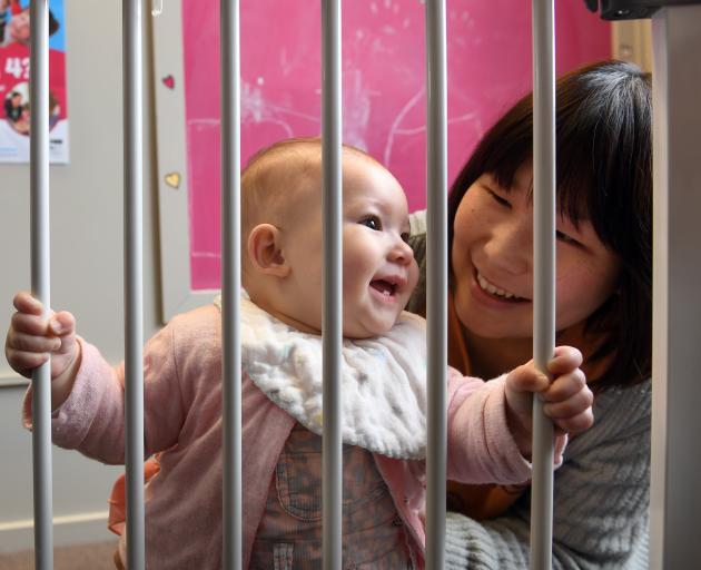 Madoka Yamauchi and her daughter Mia McKenzie behind a safety gate given to the family by Plunket...