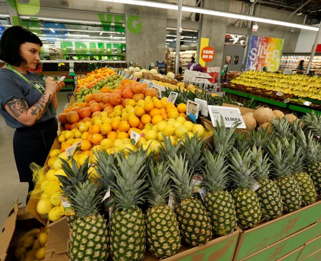 An employee checks the prices of lemons at a Whole Foods store. The US Whole Foods chain was...