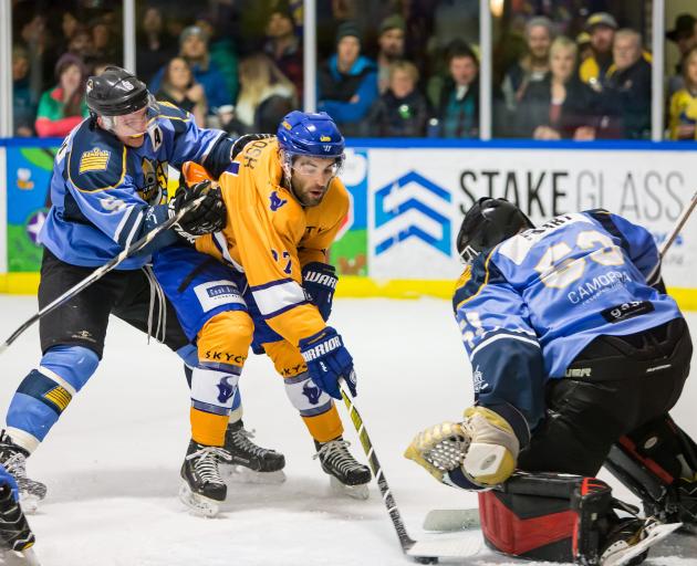 Stampede’s Colin McIntosh (centre) has his eyes on the prize during the New Zealand Ice Hockey...