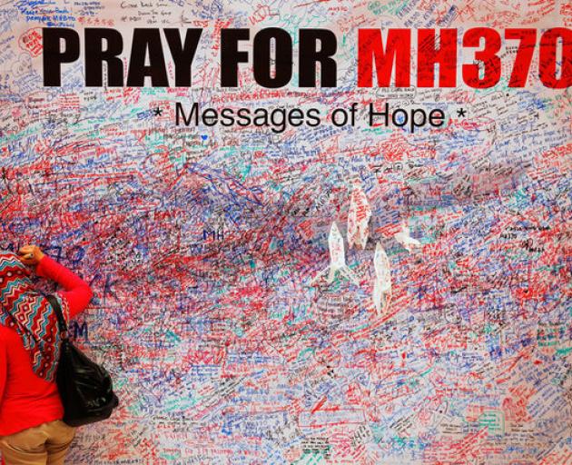 A woman leaves message of support and hope for passengers of missing Malaysia Airlines MH370 in central Kuala Lumpur. Photo: Reuters