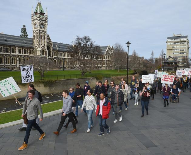 Placard-carrying University of Otago staff and students march from the University Union lawn towards the university registry yesterday to protest against proposed staff cuts. Photo: Gregor Richardson