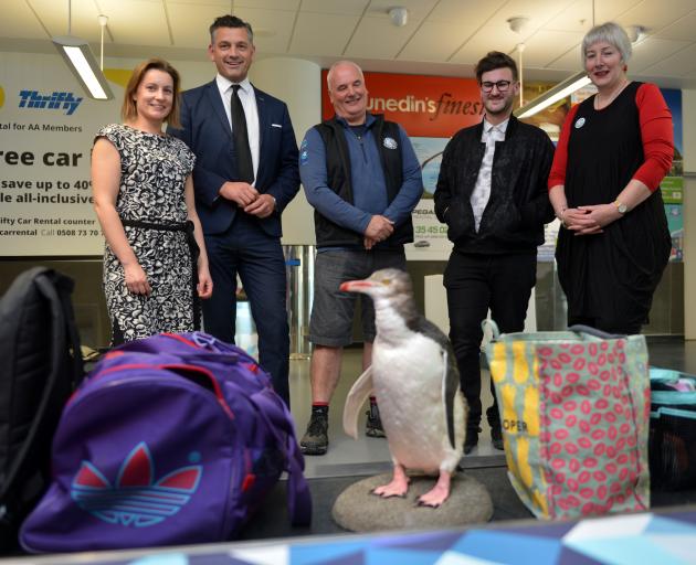 A "visitor'' makes an appearance on the Dunedin Airport baggage carousel watched by (from left)...