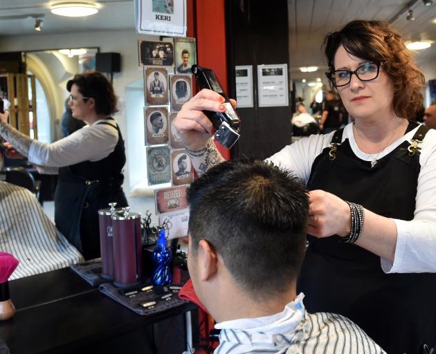 Bloke customer Harry Huang gets his hair cut by owner Keri O'Connor, without a drink in hand. Photo: Peter McIntosh