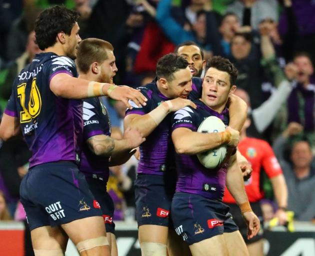 Cooper Cronk is mobbed by Melbourne Storm players after scoring a try that was later disallowed....