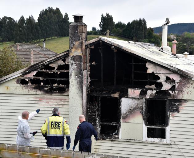 Police and emergency services staff attend the scene of a house fire in Brockville on Saturday...