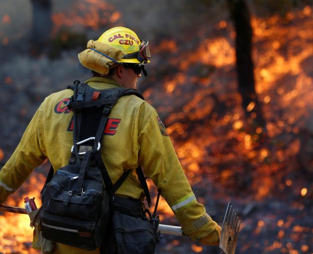 Firefighters worked to defend homes from an approaching wildfire in Sonoma. Photo: Reuters 