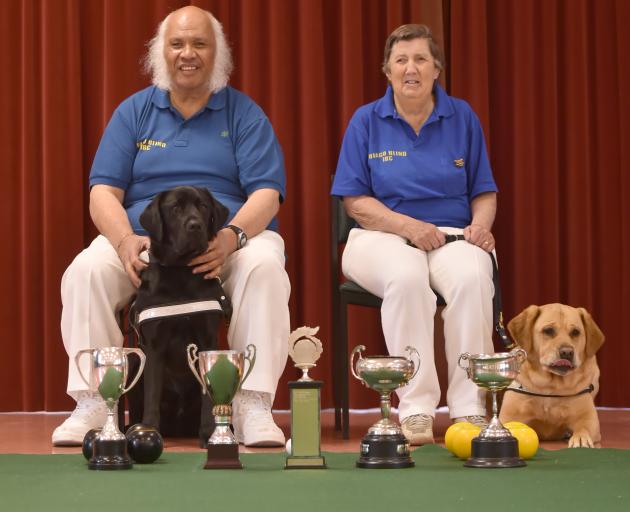 Blind indoor bowlers Nooapii Rouvi, and his guide dog, Byron, and Lynn Keogh and her guide dog, Matsi, with the spoils they collected at the national championships in Hamilton on the weekend. Photo: Gregor Richardson