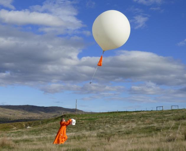 PhD student Jordis Tradowsky prepares to launch a balloon with attached climate instruments in windy conditions. The data will be compared against measurements taken from Nasa's Atmospheric Tomography Mission, which flew over Lauder on Monday as part of i