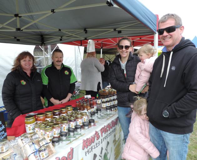 Michelle and Kevin Fayen, from North Canterbury business Kev's Pickled, discuss their products with visitors Lanee and David Harkness and daughters Edie (1) and Ruby (4). Photo: Sally Brooker