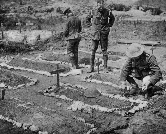 An army chaplain tending a Tommy’s grave on the Western Front. — Otago Witness, 10.10.1917. 