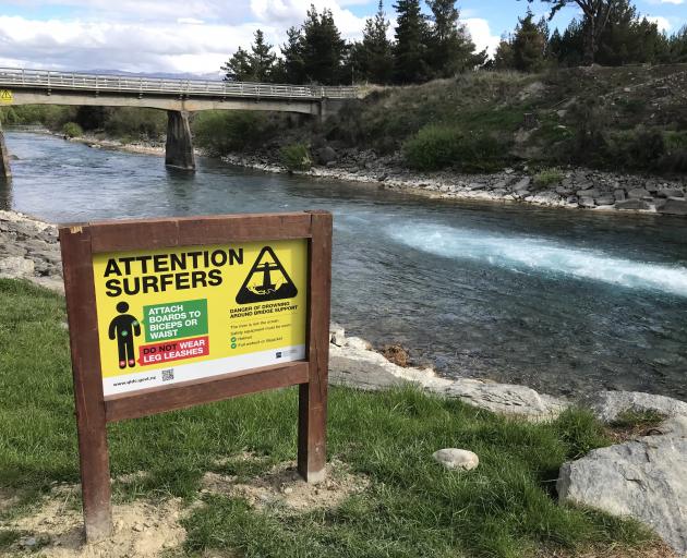 A new sign near the Hawea Whitewater Park warns surfers of the dangers of becoming tangled around the Camphill Rd bridge pylons. Photo: Supplied