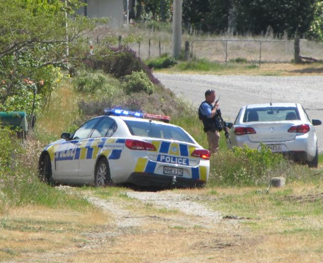 Police gather beside Lowburn Valley Rd, near Cromwell, as the search for an armed teenager continues. Photo: Pam Jones