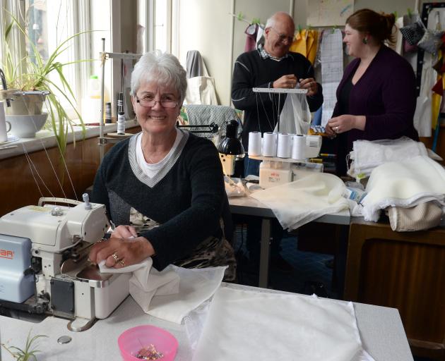 Dunedin Curtain Bank staff member Marilyn Cook with volunteer Trevor Cook and manager Tess Trotter (back right) making reusable produce bags to be given away at the Otago Farmers Market as a collaborative approach by the two entities to reduce plastic was