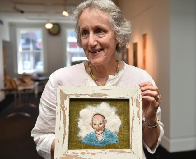 Otago Embroiderers Guild member Jenny Madill holds a work by Kingston artist Amy Baker, depicting Gareth Morgan, using stitches on felted cat fur. Photo: Gregor Richardson