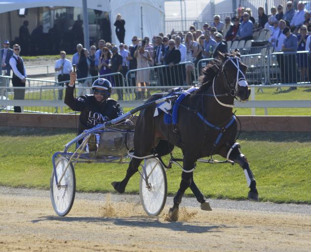 Never in doubt ... Co-trainer and driver Mark Purdon salutes the crowd after driving champion...