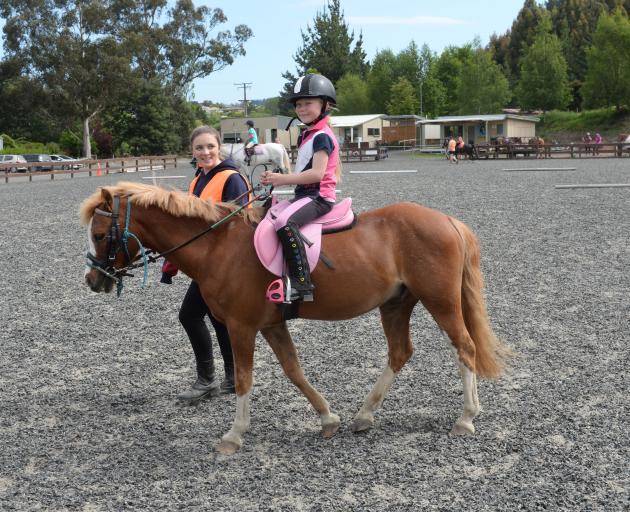 Volunteer Georgia Coleclough (15) leads Brooke Agnew (7) on Uli at the Riding for the Disabled...