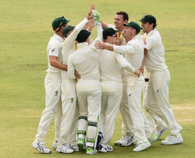 The Australian team celebrates its win over England to clinch the Ashes in Perth last night....