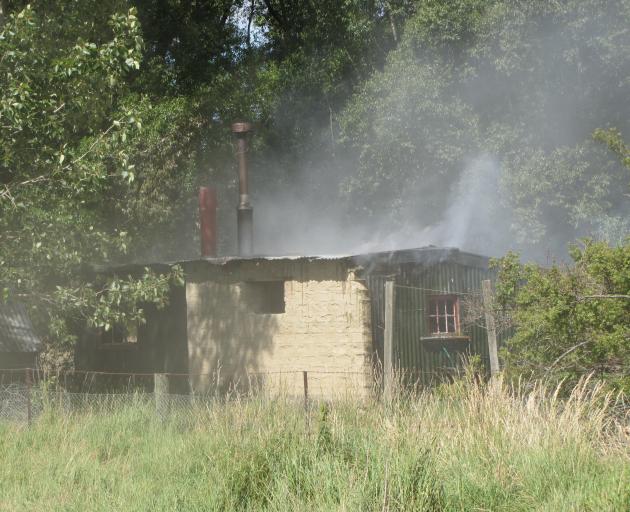 Smoke spews from a holiday house in Ophir. Photo: Pam Jones