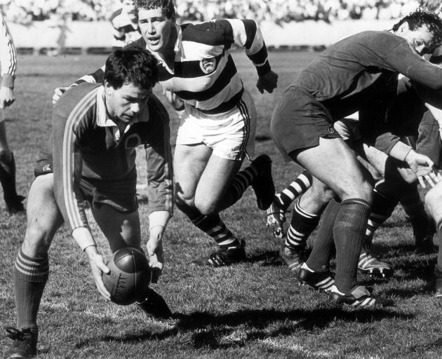 Dean Kenny looks to clear the ball under pressure from Auckland loose forward Glenn Rich at...