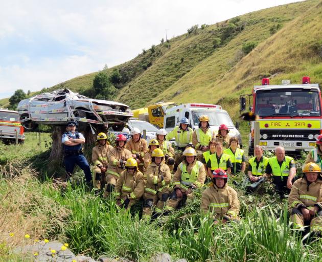 Senior Constable Craig Bennett (left), of Lawrence, and members of Fire and Emergency New Zealand and St John Ambulance have put a car that was involved in a serious crash on display in the hope it will make road users more mindful and cautious when trave