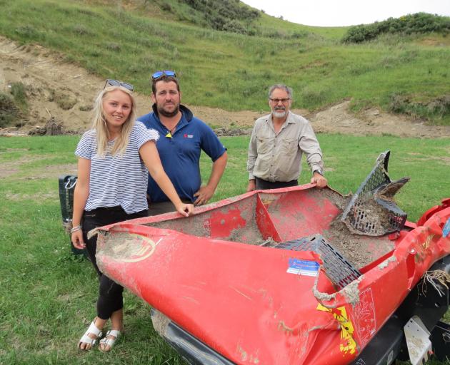 Farmers Chris Pemberton (centre), his father Rod Pemberton and his partner Jaimee Coulter, have had a busy couple of weeks cleaning up the Tima Burn Rd farm after a flash flood on November 26. Their near-new fertiliser spreader was found kilometres away i