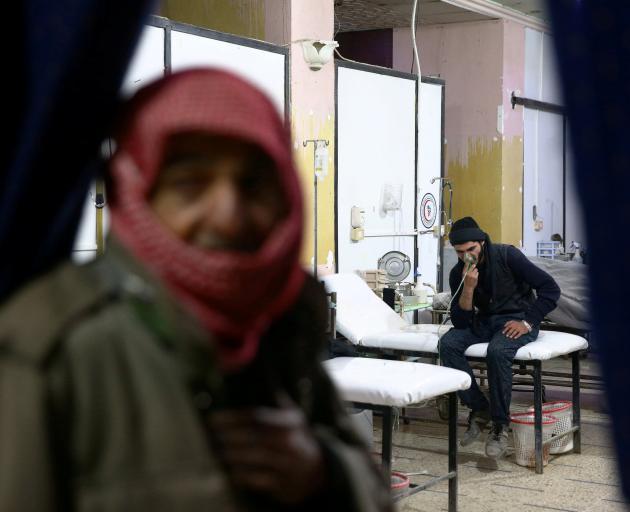 A man breathes through an oxygen mask at a medical centre in Ghouta province, the site of the...