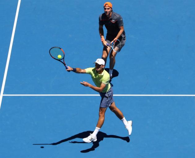 Ben McLachlan plays a shot at the net while Jan-Leppard Struff watches on during the quarterfinal...