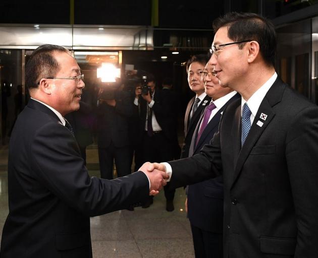 South Korean Vice Unification Minister Chun Hae-Sung, (R) shakes hands with the head of North...