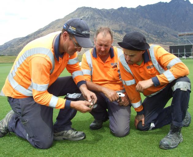 Checking a core sample from the wicket block at Queenstown's John Davies Oval on Tuesday are (from left) head groundsman Andrew Douglas, Frankton Golf Course greenkeeper Tony Reid and assistant groundsman Jesse Wright. Photo: Guy Williams
