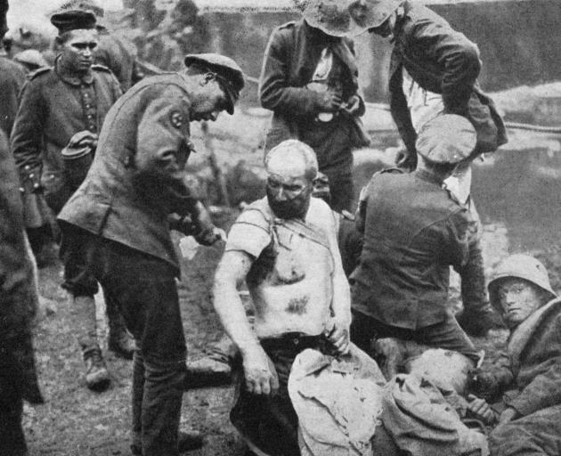 The battle of Broodseynde: R.A.M.C. men dressing wounds for prisoners, who are treated similarly to our own men. - Otago Witness, 9.1.1918.