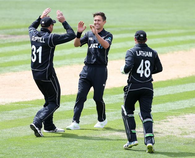 Martin Guptill, Trent Boult and Tom Latham of New Zealand celebrate the dismissal of Fakhar Zaman...