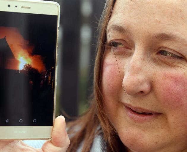 Mel Ryall displays a photo she took after rescuing an elderly man from a  Wesley St house fire...