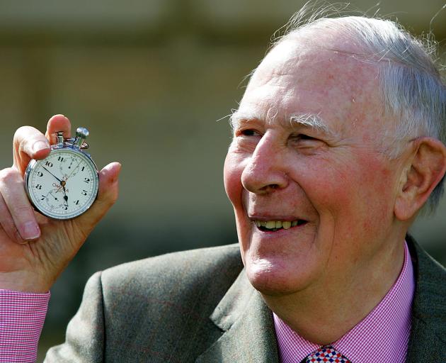 Sir Roger Bannister, who ran the first sub-four-minute mile in 1954, holds the stop watch used by...