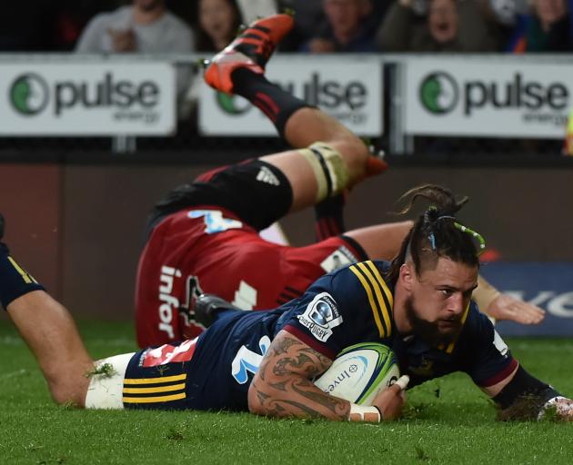 Highlanders loose forward Elliot Dixon scores a try during his team's Super Rugby match against...