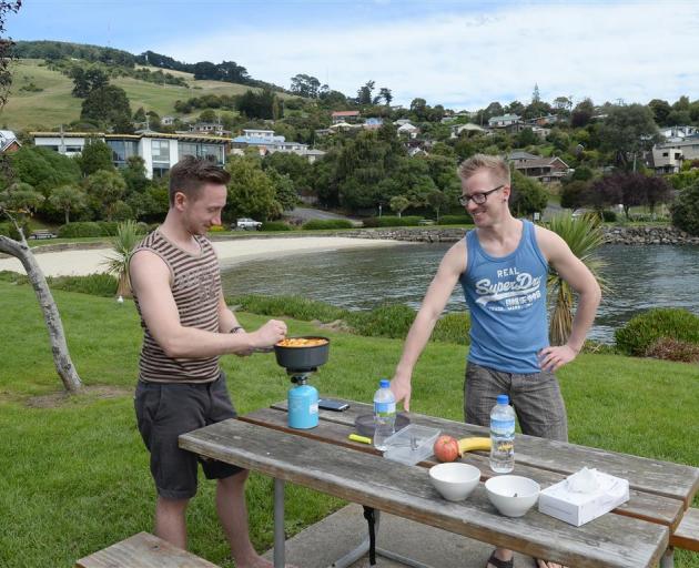 German honeymooners Hendrik (left) and Bastion Schons prepare lunch next to Macandrew Bay beach,...